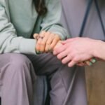 Two women holding hands in support, symbolizing care and guidance during comprehensive addiction treatment programs for recovery success.