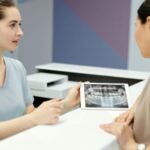 A dentist showing a dental X-ray to a patient during a consultation.