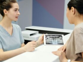 A dentist showing a dental X-ray to a patient during a consultation.