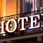 Hotel word on a iron grill outside big building, use to demonstrate Is HOTEL Really an Acronym?