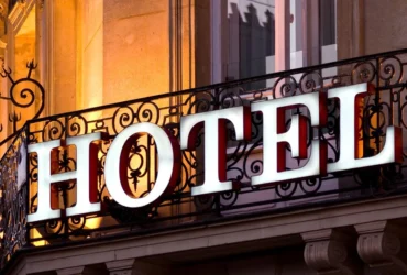 Hotel word on a iron grill outside big building, use to demonstrate Is HOTEL Really an Acronym?