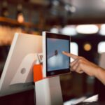 Women Hand doing process payment on touch screen cash register