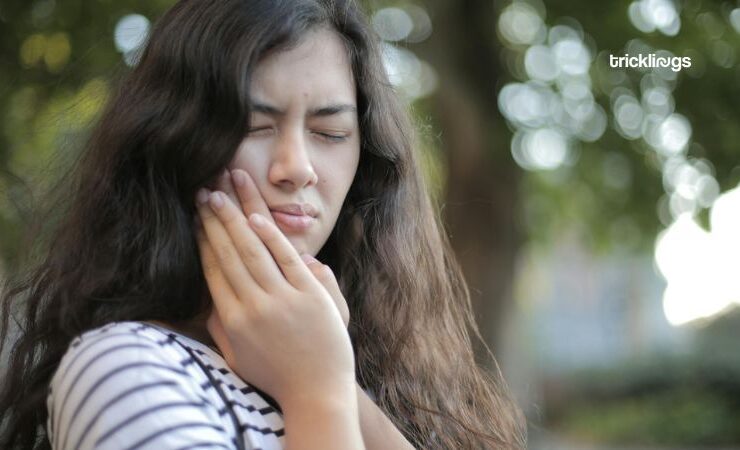 Shallow Focus on a teeth pain Photo of Woman in White and Black Stripe Shirt