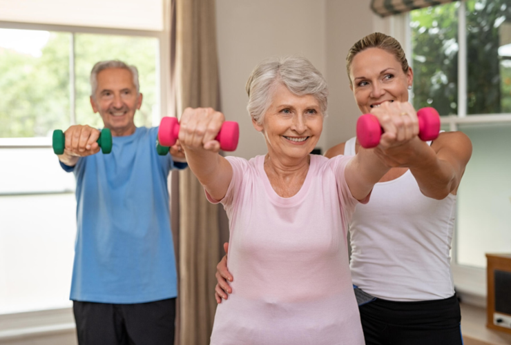 Seniors doing strength exercises with dumbbells guided by a fitness instructor.