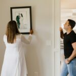 Woman in White Long Sleeve Dress Holding Black and White Picture Frame