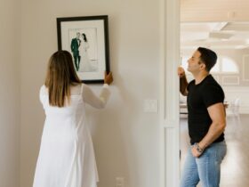 Woman in White Long Sleeve Dress Holding Black and White Picture Frame