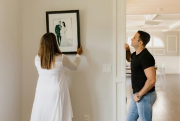 Woman in White Long Sleeve Dress Holding Black and White Picture Frame