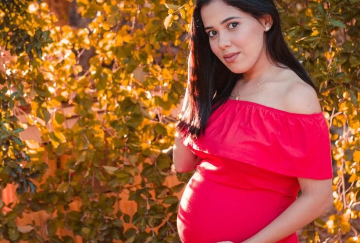 Pregnant woman in red dress representing human voice and storytelling in modern audio media