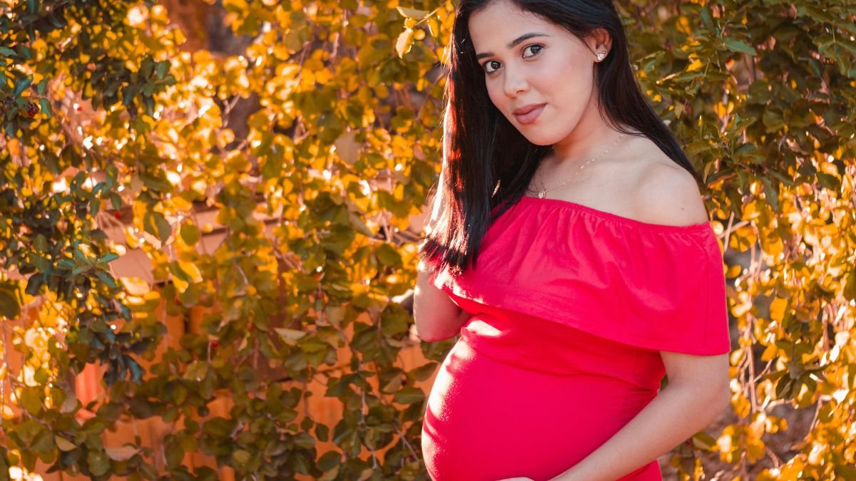 Pregnant woman in red dress representing human voice and storytelling in modern audio media