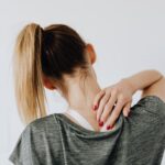 Woman touching her back, representing the benefits of NDIS physiotherapy for pain relief and improved mobility.