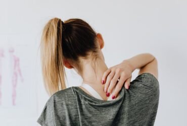 Woman touching her back, representing the benefits of NDIS physiotherapy for pain relief and improved mobility.