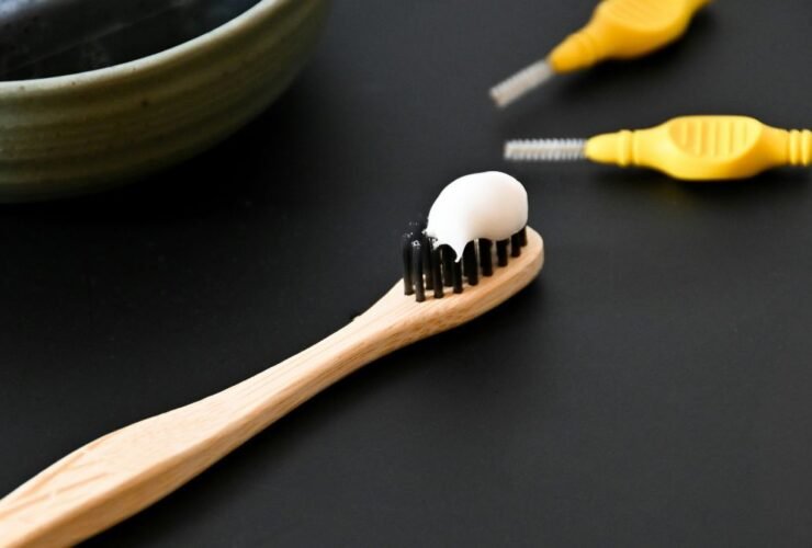 Toothbrush with toothpaste beside a bowl, representing dental care for a bright healthy smile.