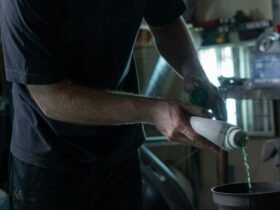 Man checking car fluids under the hood