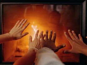 Couple’s hands near a fireplace creating a cozy winter atmosphere.