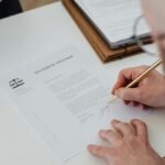 Person signing legal documents at a law firm
