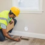 Contractor inspecting electrical socket in a modern home interior