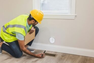 Contractor inspecting electrical socket in a modern home interior