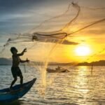 Fisherman casting a net on the lake during a fishing trip