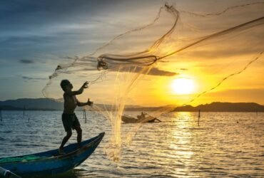 Fisherman casting a net on the lake during a fishing trip