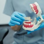 Person holding a dental model highlighting jaw discomfort awareness