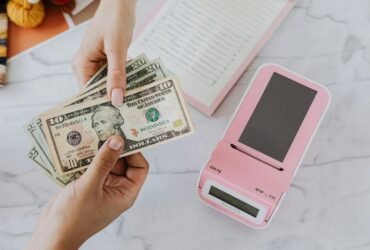 Hands holding dollar bills representing financial planning and EMI calculation