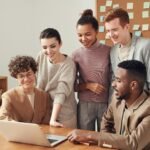 Team collaborating on laptop during HR strategy discussion