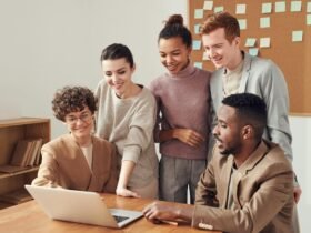Team collaborating on laptop during HR strategy discussion