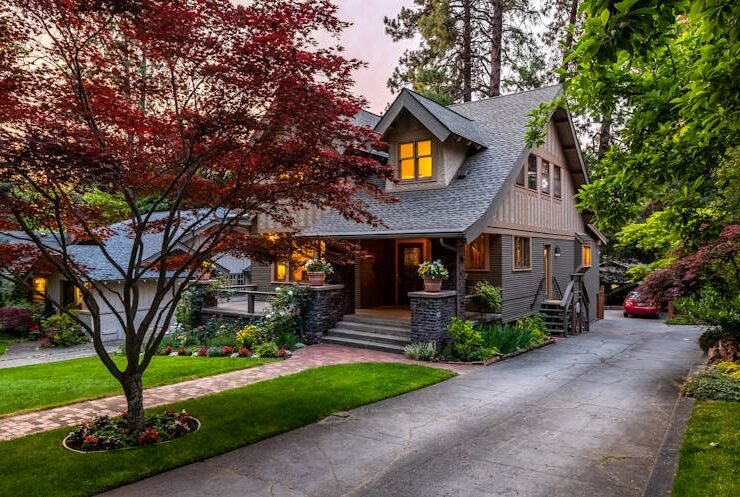 Brown and white wooden house surrounded by green trees, symbolizing a transition from a starter home to a forever home.