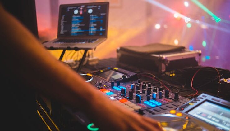 Photo by Erik Mclean - Dj with mixer controller in night club