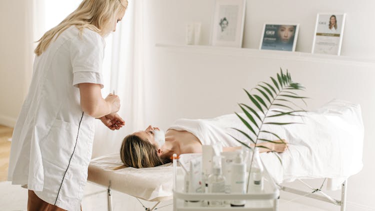 Photo by Ivan Samkov - A Dermatologist Applying Facial Mask on Customer's Face