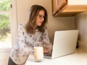 Woman Using Gray Laptop Computer in Kitchen