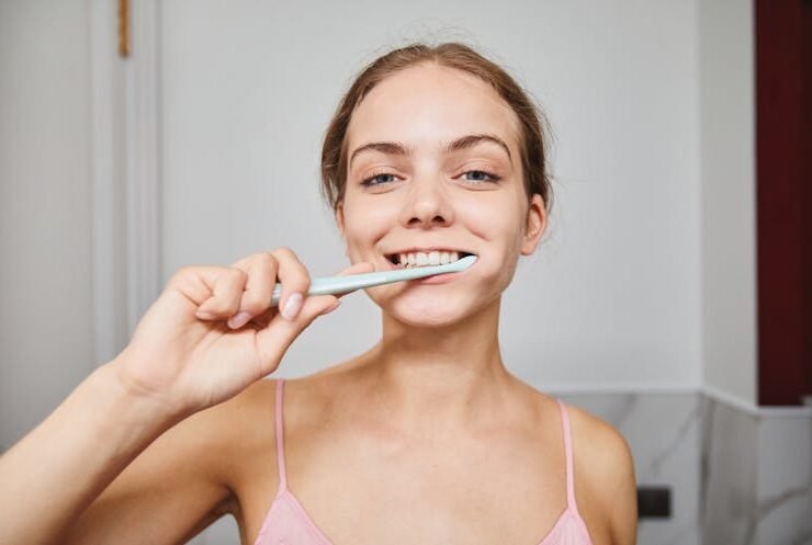 Woman brushing her teeth to maintain dental health