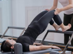 Photo by Nicholas Fu - Fitness Instructor Assisting Woman Doing Pilates