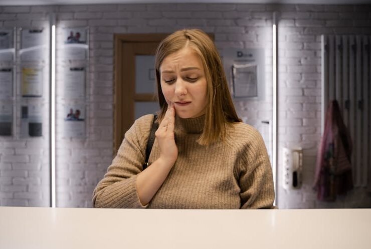Woman touching her cheeks, indicating dental discomfort