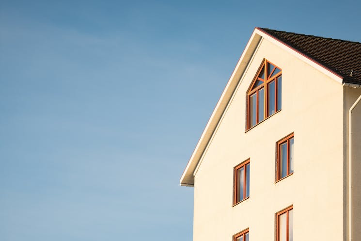 Well-maintained beige concrete house under blue sky