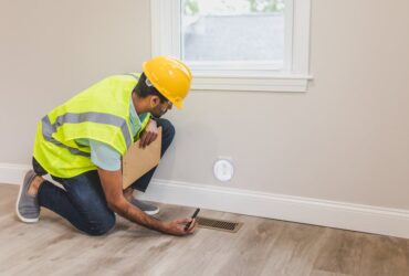 Contractor checking electrical socket for home energy efficiency