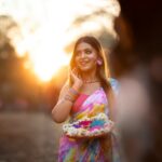 A woman celebrating Holi festival with vibrant colors, symbolizing the rich hues of pitaya powder.