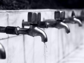 Water dripping from a household faucet representing plumbing issues.
