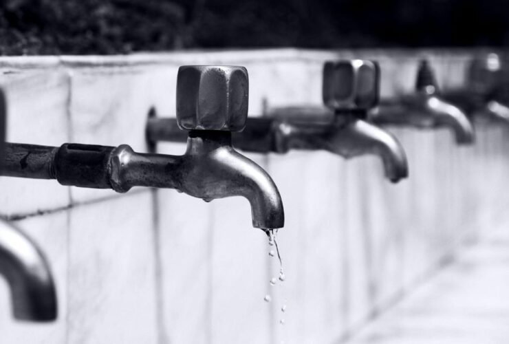 Water dripping from a household faucet representing plumbing issues.