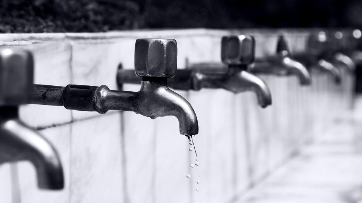 Water dripping from a household faucet representing plumbing issues.