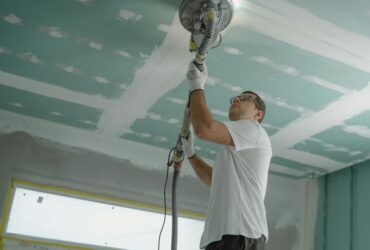 Construction worker polishing ceiling inside a home in Chennai