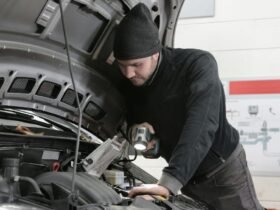 Man checking car engine during road trip preparation