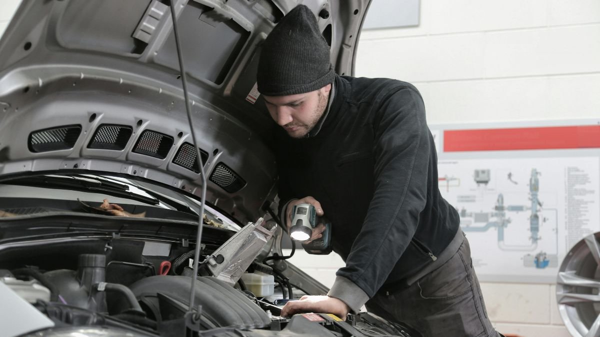Man checking car engine during road trip preparation
