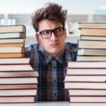 Student with different books representing exam preparation load