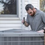 Technician inspecting an outdoor HVAC unit for maintenance.