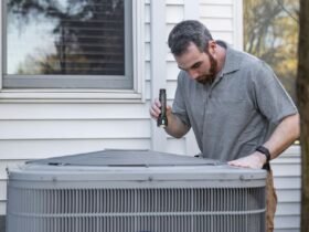 Technician inspecting an outdoor HVAC unit for maintenance.