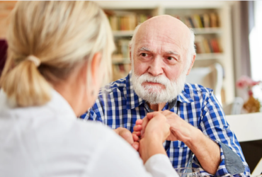 Compassionate nurse comforting an elderly dementia patient.