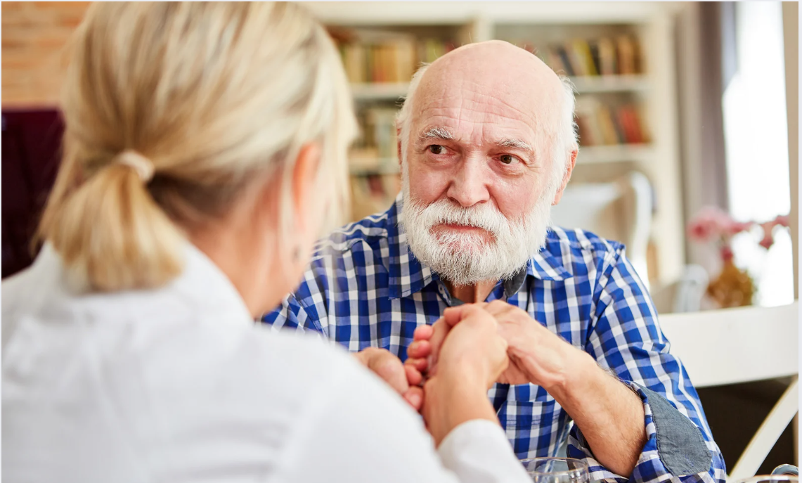 Compassionate nurse comforting an elderly dementia patient.