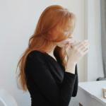 Woman practicing self-care while sitting indoors and relaxing