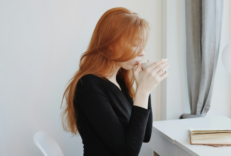 Woman practicing self-care while sitting indoors and relaxing